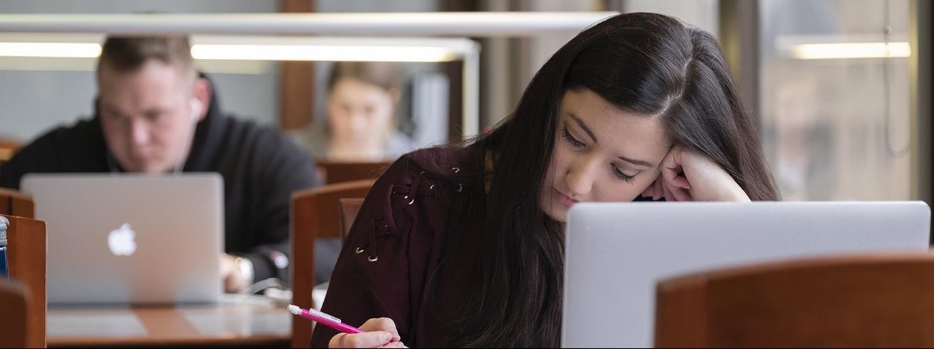 students studying with laptops in library