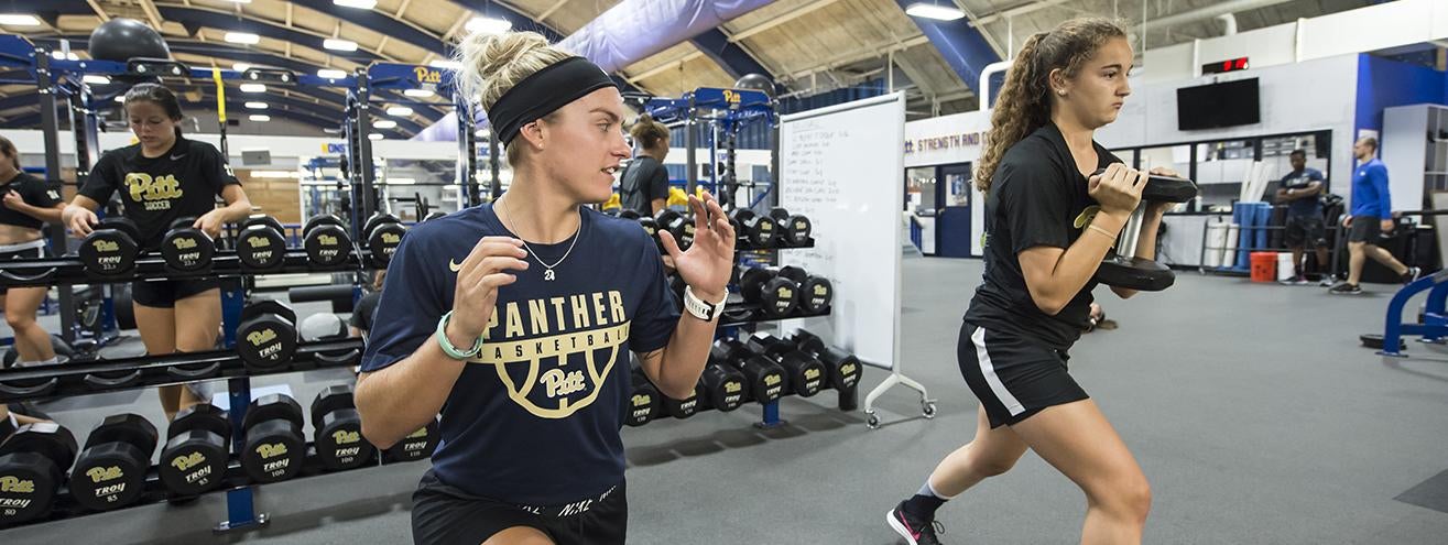 two students exercising in gym