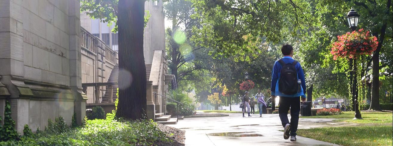 student walking on walkway outside Cathedral of Learning