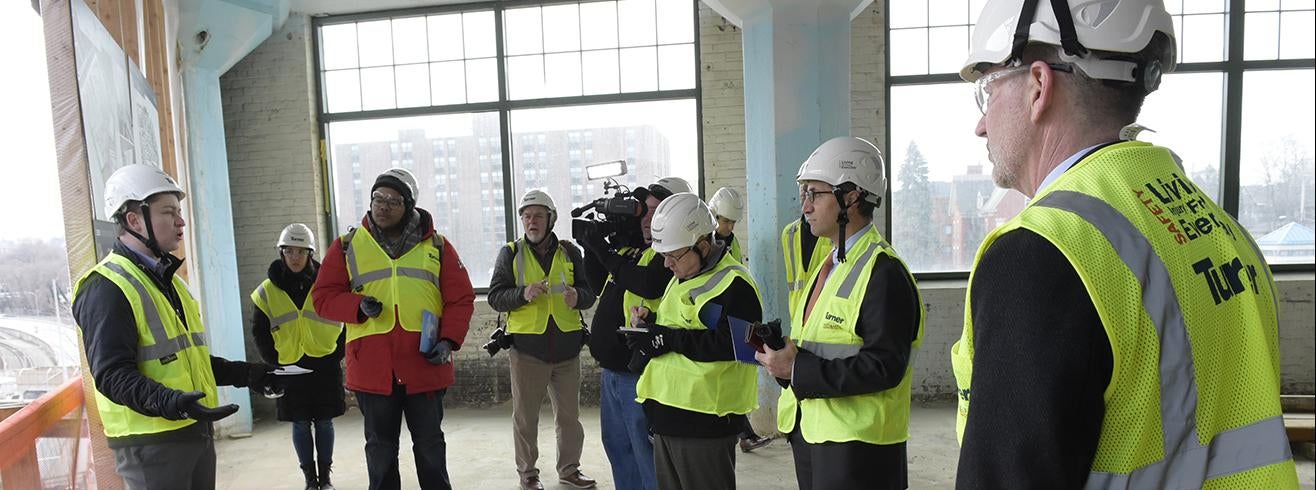 people in hardhats and reflective vests at construction site