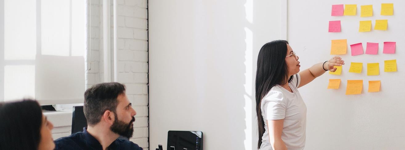 people in meeting looking at post-it notes on wall Photo by Leon on Unsplash