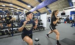 two students exercising in gym