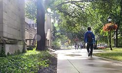 student walking on walkway outside Cathedral of Learning