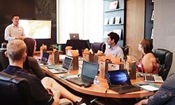 group of people around conference table looking toward presenter