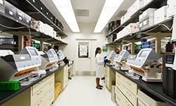 A technician works among desktop genomic sequencing machines