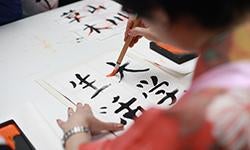 person holding brush drawing kanji script Photo by Engin Akyurt from Pexels