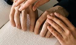 person touching and reading braille book pages