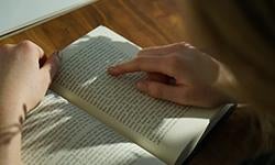 closeup of person's hands holding a book open